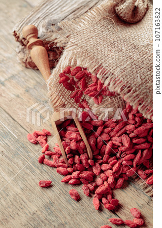 Dried goji berries on a wooden table. Dried goji berries on a wooden table. 107163822