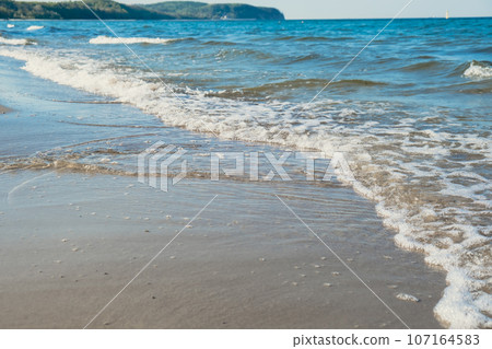 Baltic sea Dark blue clouds and sea or ocean water surface with foam waves before storm, dramatic seascape background sunsets. Abstract pattern texture. 107164583