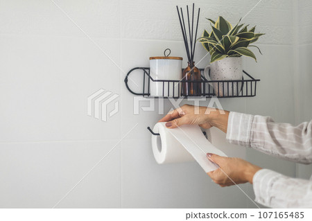 Close-up of a man's hand using white toilet paper. Close-up of a man's hand using white toilet paper. 107165485