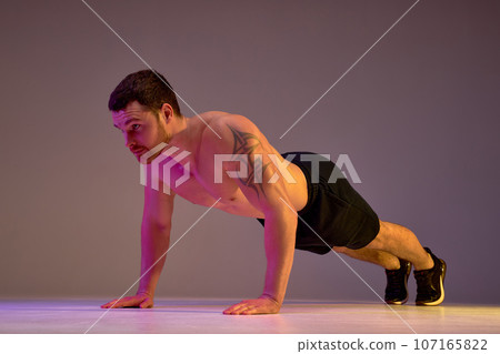 young handsome motivated man doing push-ups young handsome motivated man doing push-ups 107165822