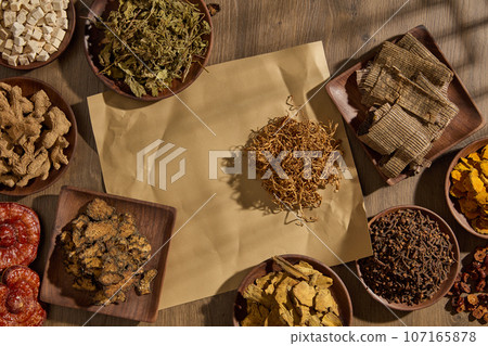 Healthy medicine concept with different types of traditional herbal medicine arranged with an empty space in the middle. Healthy product promotion 107165878