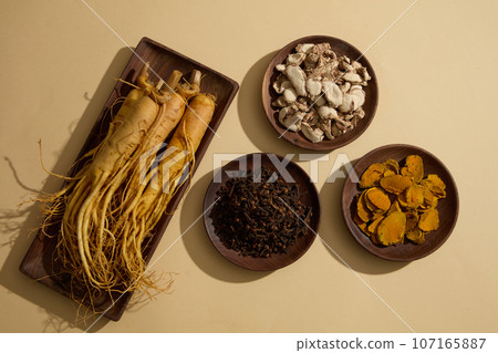 Wooden dishes featured ginseng roots, cloves, dried turmeric slices and sand ginger. These herbs have been used for the treatment of various diseases since ancient times Wooden dishes featured ginseng roots, cloves, dried turmeric slices and sand ginger. These herbs have been used for the treatment of various diseases since ancient times 107165887