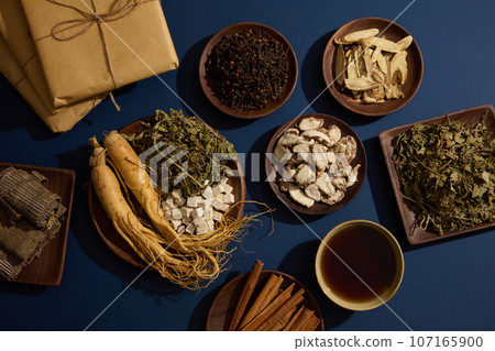 A bowl of tonic and herbal medicine packs are decorated with various types of traditional medicine. Traditional medicine advertising with blue background A bowl of tonic and herbal medicine packs are decorated with various types of traditional medicine. Traditional medicine advertising with blue background 107165900
