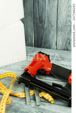 concept of furniture production and repair. Stapler and staples, working tool 107166265