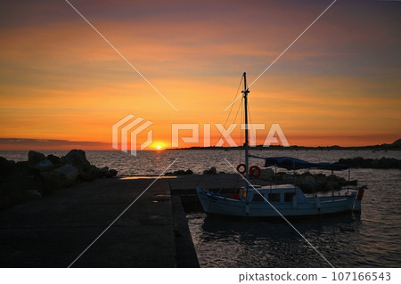 Beautiful colourful sunset on the beach with the sea and waves. A concept for travel, holidays and summer holidays by the sea. Greece - Corfu island - Agios Georgios. Beautiful colourful sunset on the beach with the sea and waves. A concept for travel, holidays and summer holidays by the sea. Greece - Corfu island - Agios Georgios. 107166543
