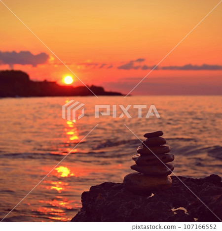 Beautiful colourful sunset on the beach with the sea and waves. A concept for travel, holidays and summer holidays by the sea. Greece - Corfu island - Agios Georgios. Beautiful colourful sunset on the beach with the sea and waves. A concept for travel, holidays and summer holidays by the sea. Greece - Corfu island - Agios Georgios. 107166552