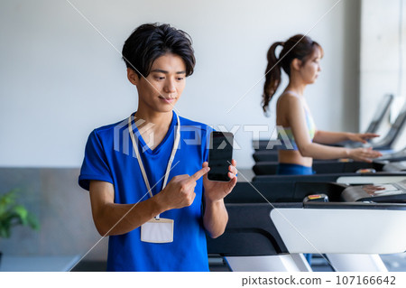 gym trainer with smartphone gym trainer with smartphone 107166642