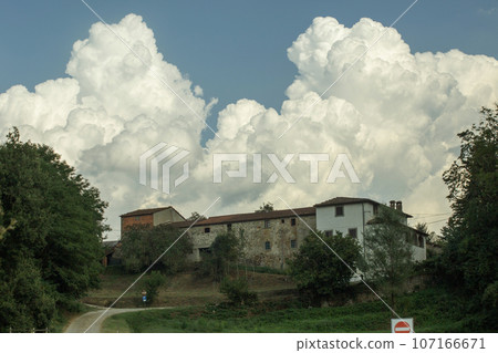 Beautiful clouds over typical rural houses in Tuscany, Italy. High quality photo 107166671