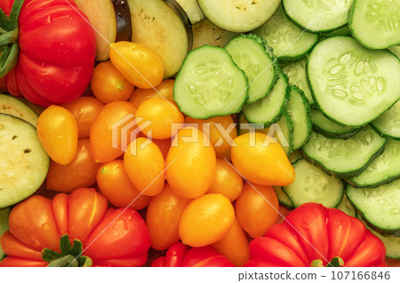 Mixed fresh vegetable background. Healthy eating ingredients. Slice of mix veggies, tomatoes, cucumbers, cherry tomato, eggplant. Nutrition, diet, vegan food. Assorted fruits rotating view closeup Mixed fresh vegetable background. Healthy eating ingredients. Slice of mix veggies, tomatoes, cucumbers, cherry tomato, eggplant. Nutrition, diet, vegan food. Assorted fruits rotating view closeup 107166846