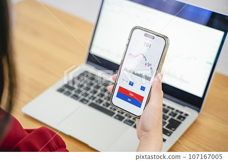 A woman investing with a smartphone A woman investing with a smartphone 107167005