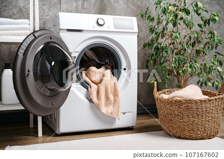Laundry room interior with washing machine near gray grunge wall 107167602