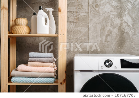 Clean folded towels on shelf in a bathroom 107167703