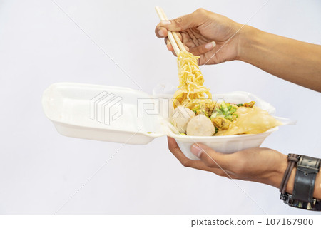 A human hand holding chicken noodles (mie ayam) A human hand holding chicken noodles (mie ayam) 107167900