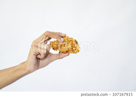 A human hand is holding a gorengan A human hand is holding a gorengan 107167915