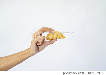 A human hand is holding a gorengan A human hand is holding a gorengan 107167916