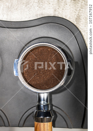 Close-up view of portafilter with fresh ground coffee Close-up view of portafilter with fresh ground coffee 107167952