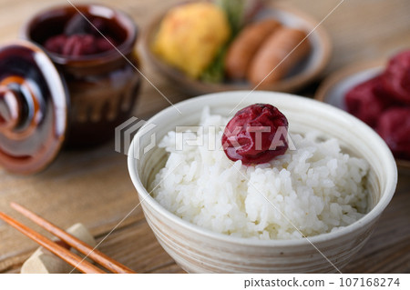 Traditional sour pickled plums (Kishu Nankoume) served with warm rice. Traditional sour pickled plums (Kishu Nankoume) served with warm rice. 107168274