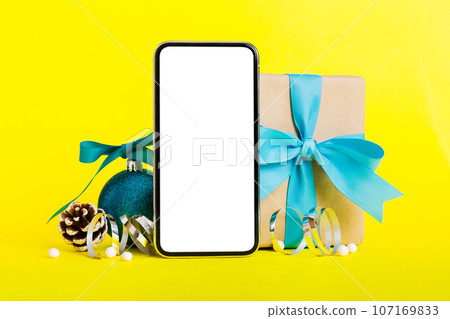 Digital phone mock up with rustic Christmas decorations for app presentation with empty space for you design. Christmas online shopping concept. Tablet with copy space on colored background 107169833