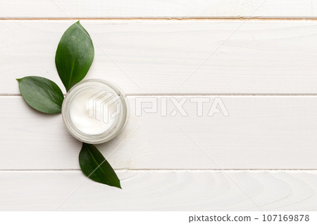 Organic cosmetic products with green leaves on wooden background. Copy space, flat lay Organic cosmetic products with green leaves on wooden background. Copy space, flat lay 107169878