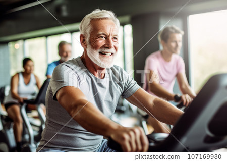 Portrait of senior man training on stationary bike workout in gym. Concept senior active lifestyle. Generative Ai 107169980