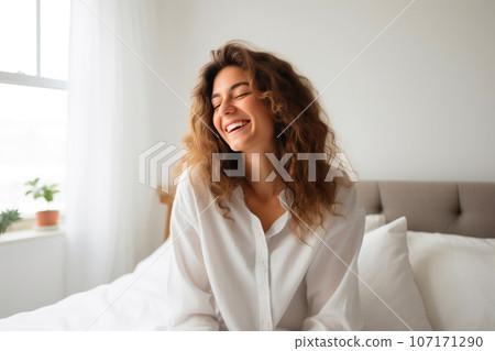 Young Woman Relaxing with Her Smartphone in Bed Young Woman Relaxing with Her Smartphone in Bed 107171290