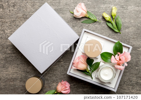 Composition with cosmetic products and beautiful roses on cement background. Flat lay Composition with cosmetic products and beautiful roses on cement background. Flat lay 107171420
