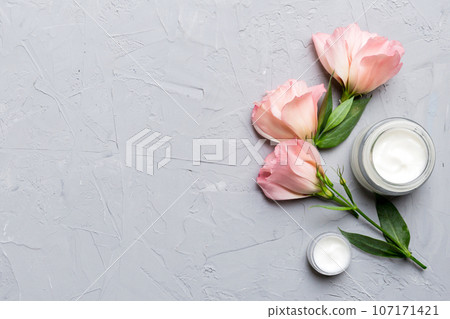 Composition with cosmetic products and beautiful roses on cement background. Copy space, flat lay Composition with cosmetic products and beautiful roses on cement background. Copy space, flat lay 107171421