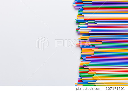 Heap of colorful plastic drinking straws on Colored background, flat lay. Copy Space for text 107171501