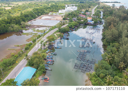 Aerial view of fishing trap net in canel with fisherman urban city village town houses, lake or river. Nature landscape fisheries and fishing tools at Pak Pha, Songkhla, Thailand. Aquaculture farming 107173110
