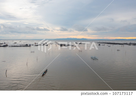 Aerial view of fishing trap net in canel with fisherman urban city village town houses, lake or river. Nature landscape fisheries and fishing tools at Pak Pha, Songkhla, Thailand. Aquaculture farming 107173117