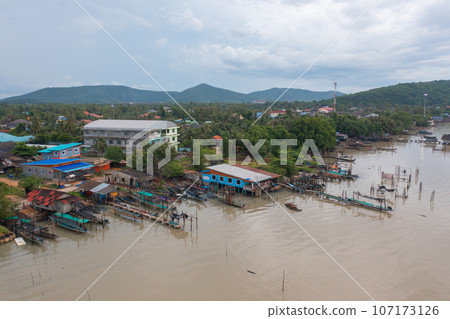 Aerial view of fishing trap net in canel with fisherman urban city village town houses, lake or river. Nature landscape fisheries and fishing tools at Pak Pha, Songkhla, Thailand. Aquaculture farming 107173126