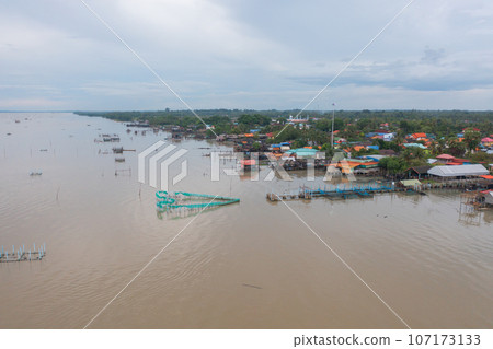 Aerial view of fishing trap net in canel with fisherman urban city village town houses, lake or river. Nature landscape fisheries and fishing tools at Pak Pha, Songkhla, Thailand. Aquaculture farming 107173133