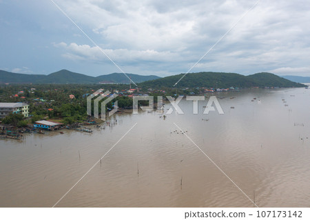 Aerial view of fishing trap net in canel with fisherman urban city village town houses, lake or river. Nature landscape fisheries and fishing tools at Pak Pha, Songkhla, Thailand. Aquaculture farming 107173142