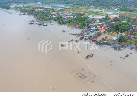 Aerial view of fishing trap net in canel with fisherman urban city village town houses, lake or river. Nature landscape fisheries and fishing tools at Pak Pha, Songkhla, Thailand. Aquaculture farming 107173186