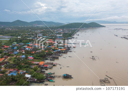 Aerial view of fishing trap net in canel with fisherman urban city village town houses, lake or river. Nature landscape fisheries and fishing tools at Pak Pha, Songkhla, Thailand. Aquaculture farming Aerial view of fishing trap net in canel with fisherman urban city village town houses, lake or river. Nature landscape fisheries and fishing tools at Pak Pha, Songkhla, Thailand. Aquaculture farming 107173191