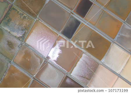 Aerial view of natural sea salt ponds, lake or sea. Farm field outdoor in traditional industry in Thailand. Asia culture. Agriculture irrigation. River reflection. 107173199