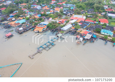 Aerial view of fishing trap net in canel with fisherman urban city village town houses, lake or river. Nature landscape fisheries and fishing tools at Pak Pha, Songkhla, Thailand. Aquaculture farming 107173200