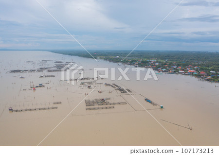 Aerial view of fishing trap net in canel with fisherman urban city village town houses, lake or river. Nature landscape fisheries and fishing tools at Pak Pha, Songkhla, Thailand. Aquaculture farming Aerial view of fishing trap net in canel with fisherman urban city village town houses, lake or river. Nature landscape fisheries and fishing tools at Pak Pha, Songkhla, Thailand. Aquaculture farming 107173213