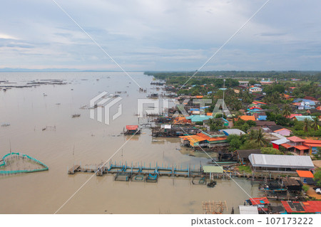 Aerial view of fishing trap net in canel with fisherman urban city village town houses, lake or river. Nature landscape fisheries and fishing tools at Pak Pha, Songkhla, Thailand. Aquaculture farming Aerial view of fishing trap net in canel with fisherman urban city village town houses, lake or river. Nature landscape fisheries and fishing tools at Pak Pha, Songkhla, Thailand. Aquaculture farming 107173222