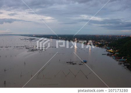 Aerial view of fishing trap net in canel with fisherman urban city village town houses, lake or river. Nature landscape fisheries and fishing tools at Pak Pha, Songkhla, Thailand. Aquaculture farming Aerial view of fishing trap net in canel with fisherman urban city village town houses, lake or river. Nature landscape fisheries and fishing tools at Pak Pha, Songkhla, Thailand. Aquaculture farming 107173280
