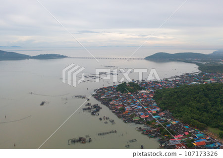Aerial view of fishing trap net in canel with fisherman urban city village town houses, lake or river. Nature landscape fisheries and fishing tools at Pak Pha, Songkhla, Thailand. Aquaculture farming Aerial view of fishing trap net in canel with fisherman urban city village town houses, lake or river. Nature landscape fisheries and fishing tools at Pak Pha, Songkhla, Thailand. Aquaculture farming 107173326