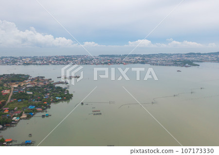 Aerial view of fishing trap net in canel with fisherman urban city village town houses, lake or river. Nature landscape fisheries and fishing tools at Pak Pha, Songkhla, Thailand. Aquaculture farming Aerial view of fishing trap net in canel with fisherman urban city village town houses, lake or river. Nature landscape fisheries and fishing tools at Pak Pha, Songkhla, Thailand. Aquaculture farming 107173330