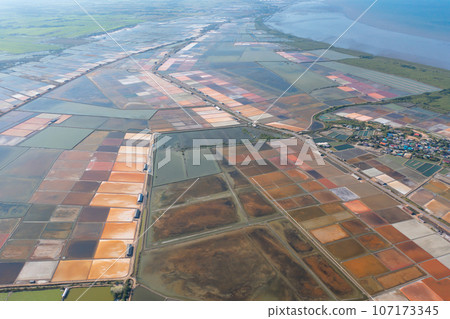 Aerial view of natural sea salt ponds, lake or sea. Farm field outdoor in traditional industry in Thailand. Asia culture. Agriculture irrigation. River reflection. 107173345