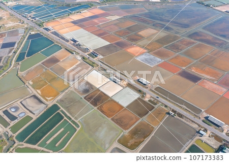 Aerial view of natural sea salt ponds, lake or sea. Farm field outdoor in traditional industry in Thailand. Asia culture. Agriculture irrigation. River reflection. 107173383