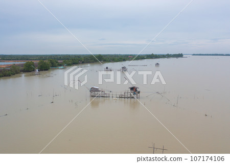 Aerial view of fishing trap net in canel with fisherman urban city village town houses, lake or river. Nature landscape fisheries and fishing tools at Pak Pha, Songkhla, Thailand. Aquaculture farming Aerial view of fishing trap net in canel with fisherman urban city village town houses, lake or river. Nature landscape fisheries and fishing tools at Pak Pha, Songkhla, Thailand. Aquaculture farming 107174106
