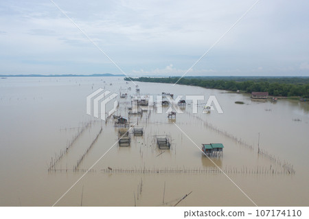 Aerial view of fishing trap net in canel with fisherman urban city village town houses, lake or river. Nature landscape fisheries and fishing tools at Pak Pha, Songkhla, Thailand. Aquaculture farming Aerial view of fishing trap net in canel with fisherman urban city village town houses, lake or river. Nature landscape fisheries and fishing tools at Pak Pha, Songkhla, Thailand. Aquaculture farming 107174110