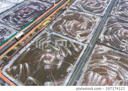 Aerial view of natural sea salt ponds, lake or sea. Farm field outdoor in traditional industry in Thailand. Asia culture. Agriculture irrigation. River reflection. Aerial view of natural sea salt ponds, lake or sea. Farm field outdoor in traditional industry in Thailand. Asia culture. Agriculture irrigation. River reflection. 107174121
