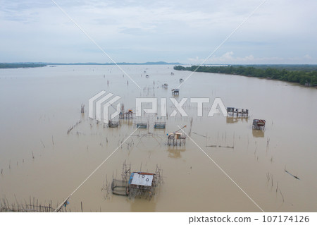 Aerial view of fishing trap net in canel with fisherman urban city village town houses, lake or river. Nature landscape fisheries and fishing tools at Pak Pha, Songkhla, Thailand. Aquaculture farming Aerial view of fishing trap net in canel with fisherman urban city village town houses, lake or river. Nature landscape fisheries and fishing tools at Pak Pha, Songkhla, Thailand. Aquaculture farming 107174126