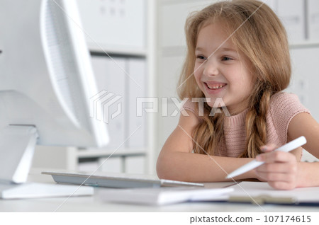 Cute and happy little girl children using laptop computer Cute and happy little girl children using laptop computer 107174615