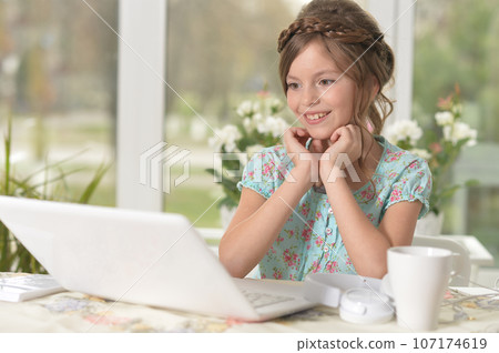 Cute and happy little girl children using laptop computer Cute and happy little girl children using laptop computer 107174619